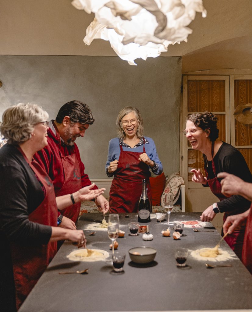 Group of Accidental Tourist guests sharing a joyful moment during a January tour, laughing together in a cozy, rustic setting